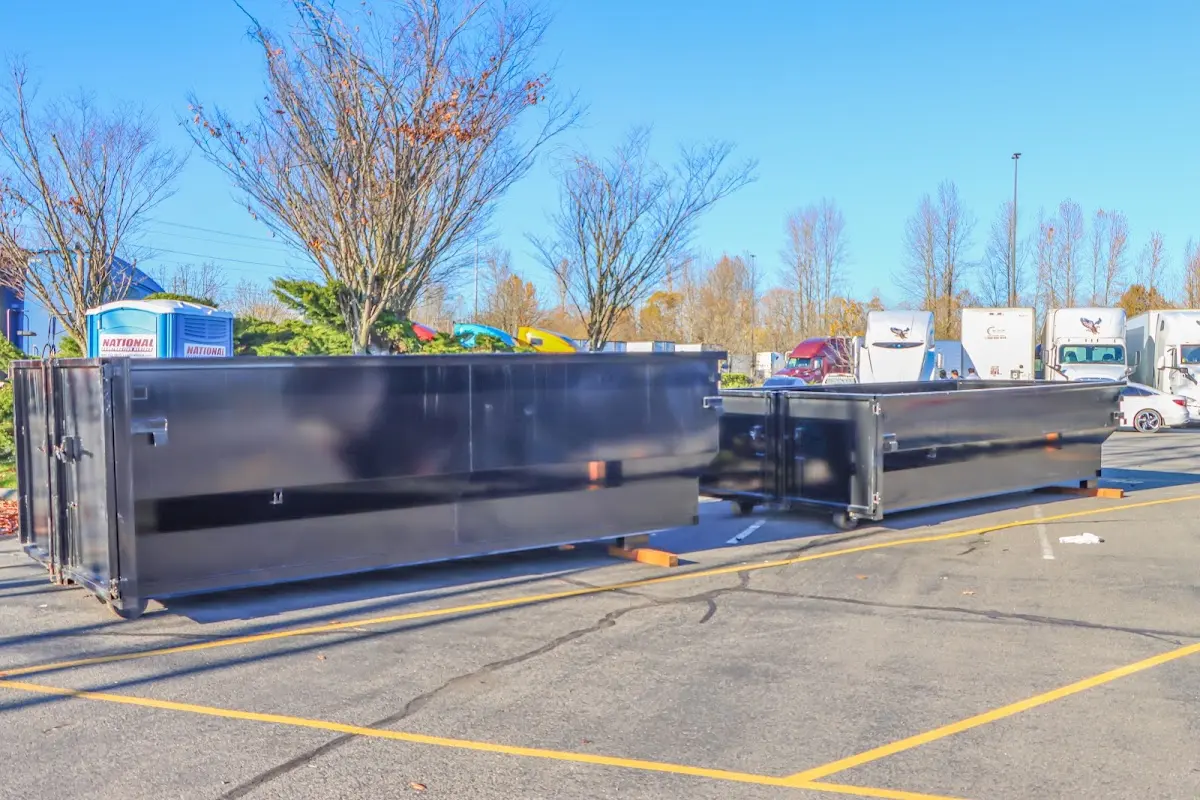 Professional dumpster rental service with roll-off container on residential driveway in Medford